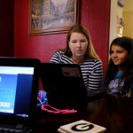 A mom and her daughter go over school lessons using a laptop computer