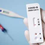 A hand holds a Covid rapid test device
