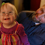 A man plays with his daughter who was born with Down syndrome.