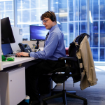 Justin Pierce, who has autism and works as an account support associate, sits at his desk at EY offices in Chicago in 2019.