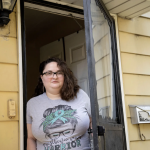 Kathryn Wiltz leans out of an outside door at her home.
