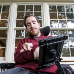 Benjamin Shrader at his home in Greenville. Shrader uses a power chair with an AAC device.