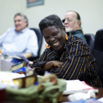 Lois Curtis sits at a conference table, smiling brightly.