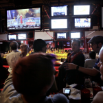 A crowded bar with several tvs.
