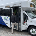 A person steps into a DART paratransit bus