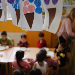 Blurred image of small children in a classroom with a teacher