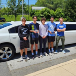 A group of five teens from Brandywine High School stand in front of a stretch limo